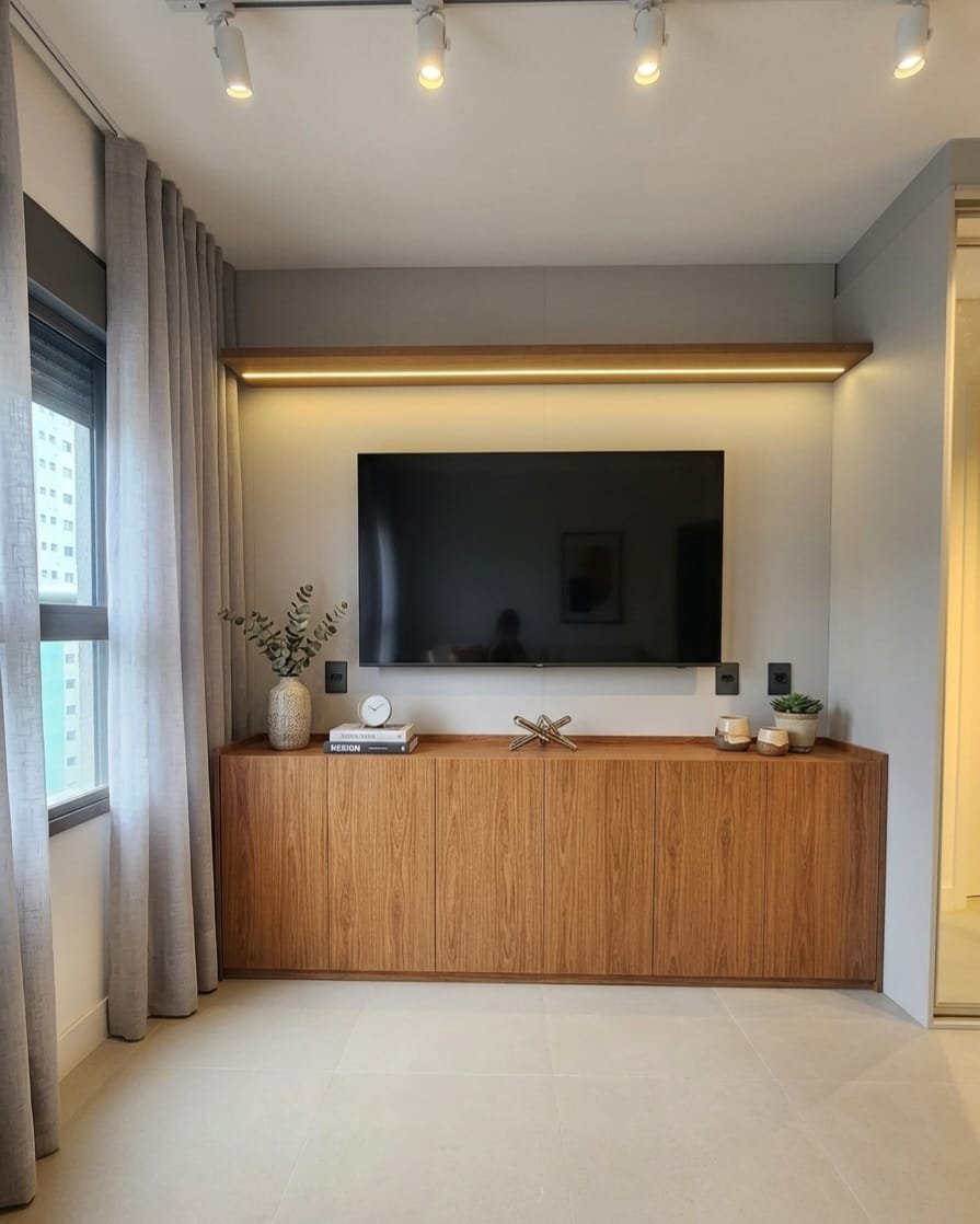 Sala Novais com painel de TV e balcão em madeira natural