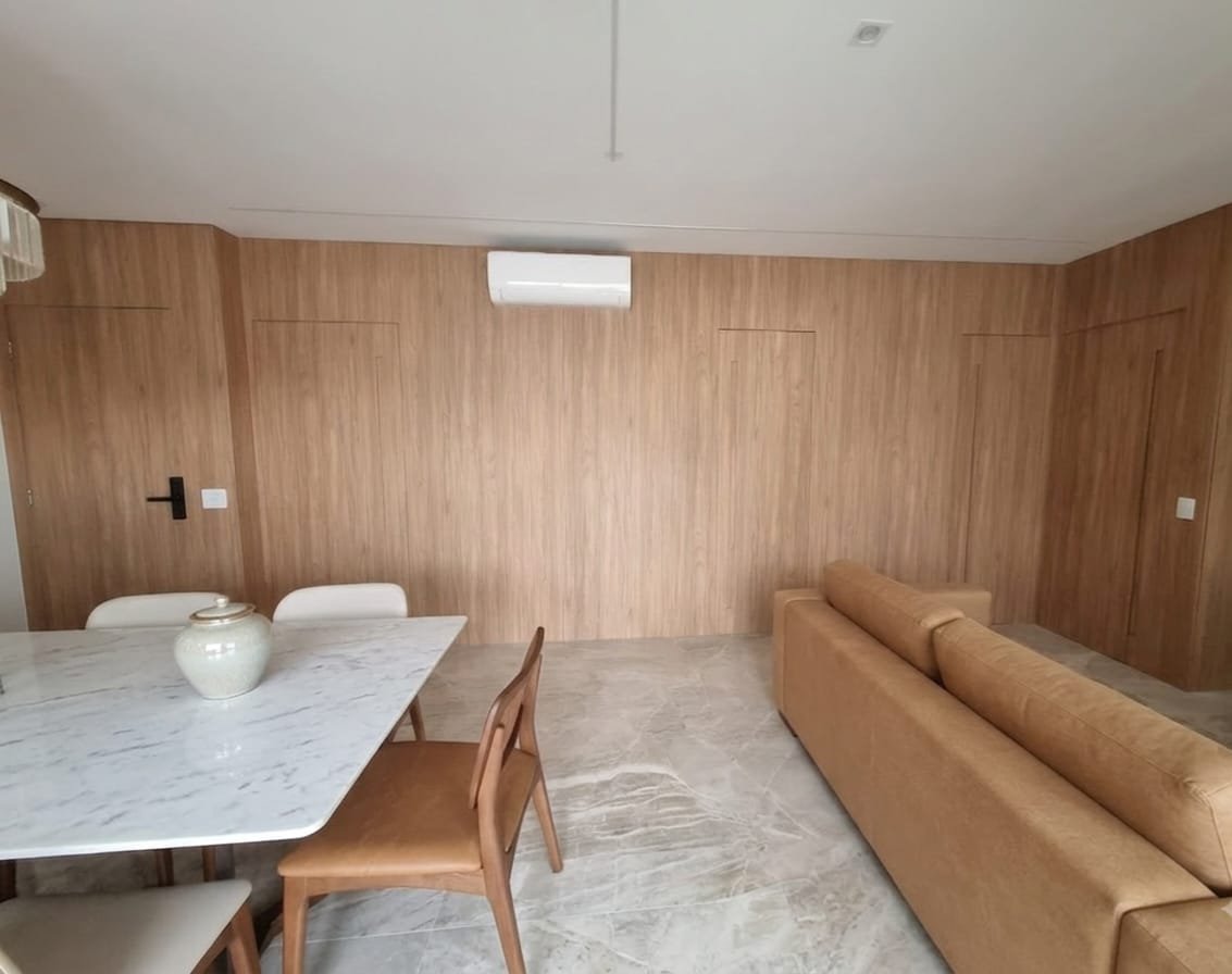 Sala de jantar Novais com parede revestida em madeira e portas integradas